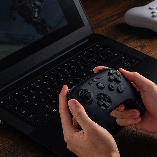 8BitDo 64 Bluetooth – Controller – Sort – sort controller i brug med bærbar PC; producentillustration
