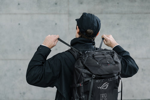 ASUS ROG Archer ErgoAir BP3800 – person justerer stropperne med rygsækken på ryggen