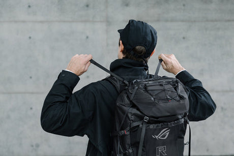 ASUS ROG Archer ErgoAir BP3800 – person justerer stropperne med rygsækken på ryggen