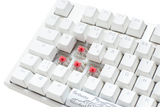 Close-up of a Ducky One 3 - Classic Pure White Nordic full-size mechanical keyboard with white PBT keycaps and visible Cherry Silent Red switches under the 'x,' 'c,' and 'v' keys, set against a light background.