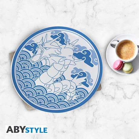 Blå Pokémon-tallerken med Gyarados-motiv på bord ved siden af kaffe